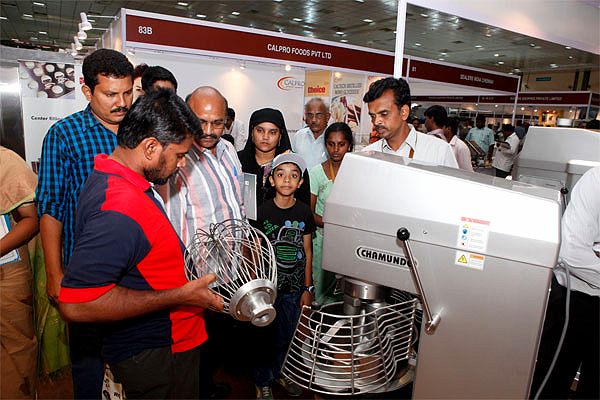 Visitors inspecting a spiral mixer bowl at Bakexpo