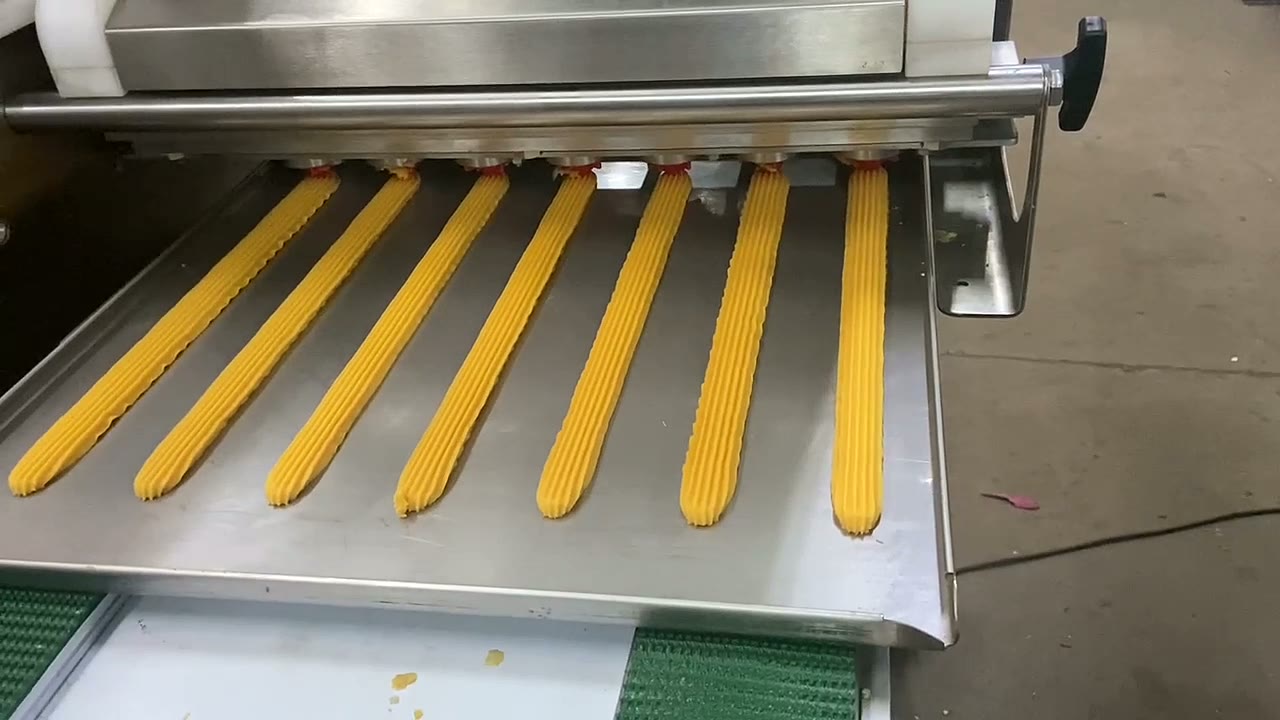 Long piped cookie bars deposited on a tray